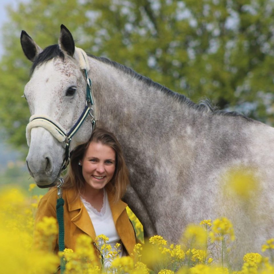 Mitglied des Reitvereins posiert mit einem Pferd