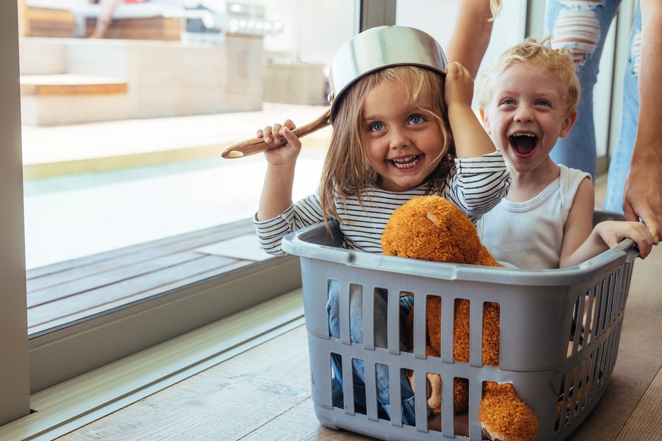 Zwei Kinder in einem Wäschekorb