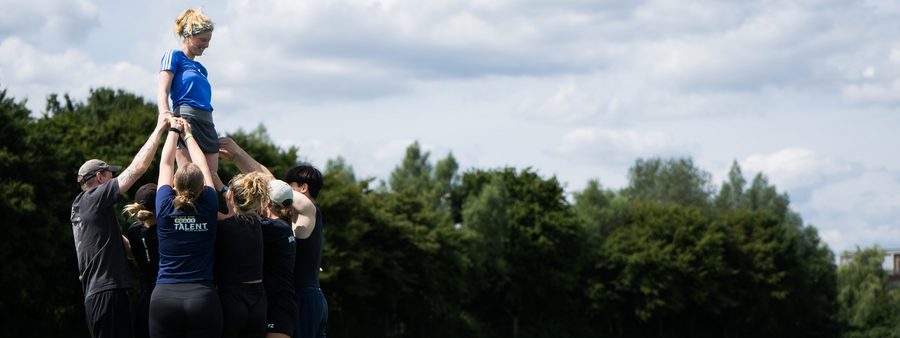 Jugendliche heben ein andere Jugendliche gemeinsam hoch