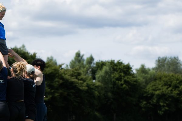 Jugendliche heben ein andere Jugendliche gemeinsam hoch