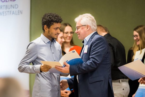 Übergabe eines Stipendiums an einen jungen Mann 