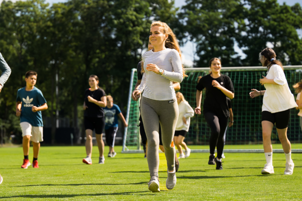 Symbolbild: Mehrere Jugendliche und Menschen machen Sport auf dem Rasen