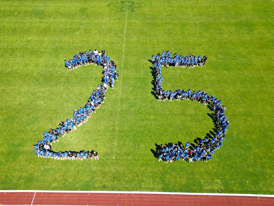 Zu sehen ist eine große 25 auf einem Spielfeld. Die Zahl besteht aus vielen Menschen, die sich für das Motiv zusammengestellt haben.